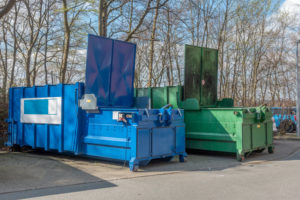 two large garbage compactors standing on a hospital site